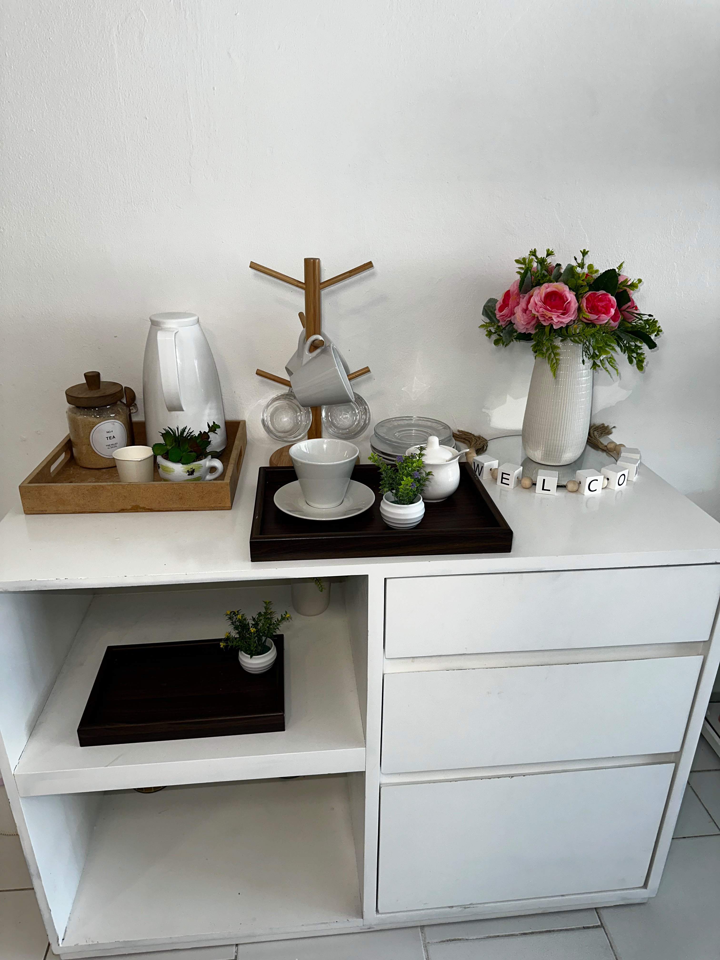 Área de bienvenida con café y flores en Bellaser